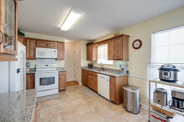 2510 Port Kembla Dr, Mount Juliet, TN 37122 - kitchen with brown cabinetry, a textured ceiling, a sink, baseboards, and white appliances