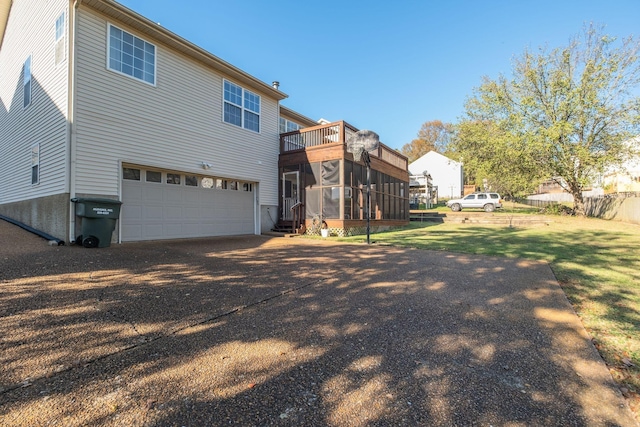 2510 Port Kembla Dr, Mount Juliet, TN 37122 - back of property featuring a lawn, driveway, a sunroom, and a garage