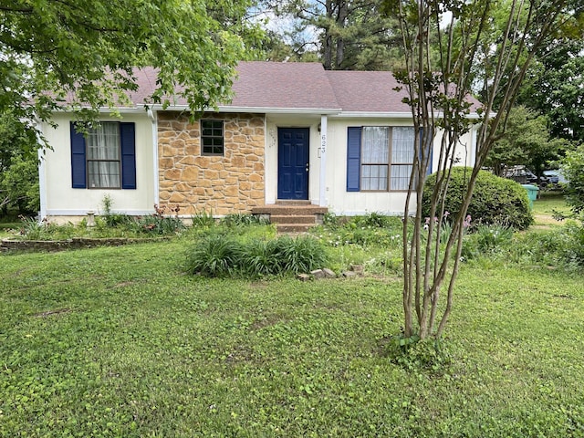 view of front of home with a front lawn, roof with shingles, and stone siding