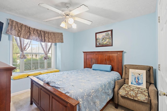 bedroom featuring baseboards, light carpet, a ceiling fan, and a textured ceiling