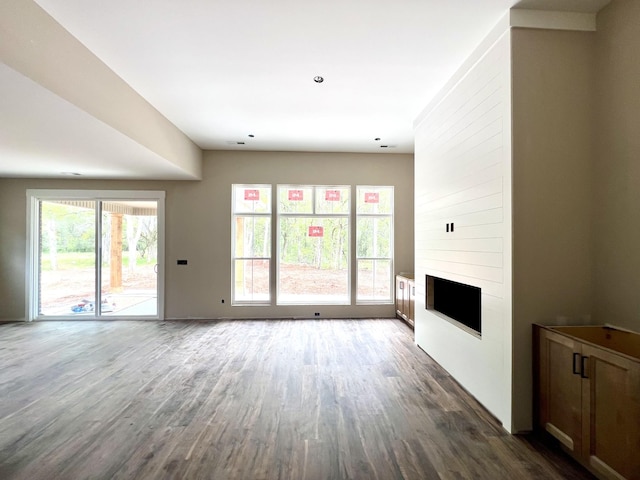 unfurnished living room with dark wood finished floors and a fireplace