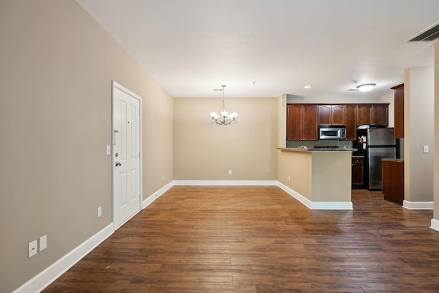 kitchen featuring an inviting chandelier, appliances with stainless steel finishes, baseboards, and dark wood-style floors