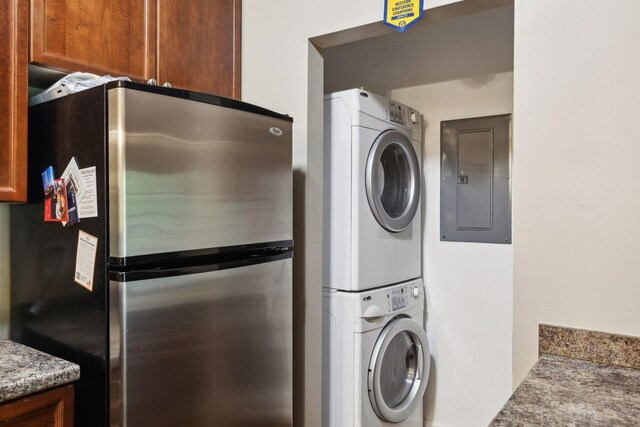 laundry area with stacked washing maching and dryer and electric panel
