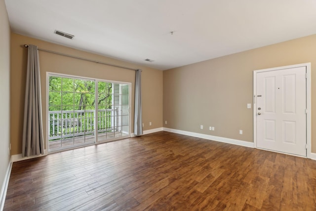 unfurnished room featuring baseboards, wood finished floors, and visible vents