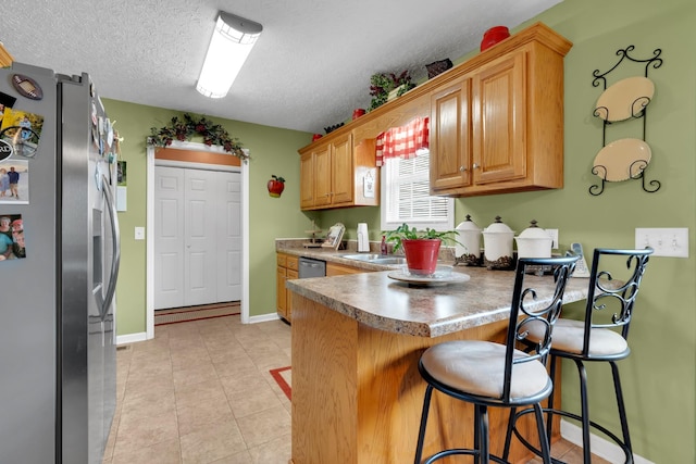 110 Broomsage Cir, Unionville, TN 37180 - kitchen with a textured ceiling, freestanding refrigerator, a peninsula, baseboards, and a kitchen bar