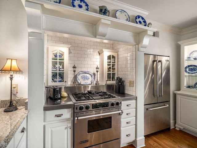 305 Davidson Rd, Nashville, TN 37205 - kitchen featuring crown molding, high quality appliances, dark wood-type flooring, white cabinetry, and tasteful backsplash