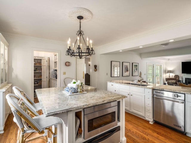 305 Davidson Rd, Nashville, TN 37205 - kitchen featuring a kitchen island, appliances with stainless steel finishes, a sink, an inviting chandelier, and white cabinetry