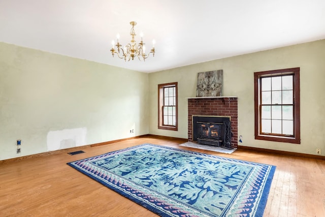 5506 Lickton Pike, Goodlettsville, TN 37072 - living room featuring wood-type flooring, visible vents, a brick fireplace, baseboards, and a chandelier