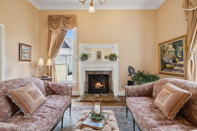 living area with ornamental molding, wood finished floors, and a lit fireplace