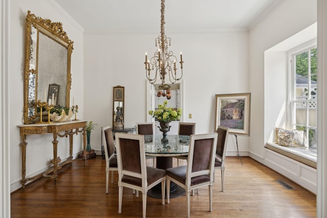 dining room featuring crown molding, visible vents, light wood-style flooring, and a chandelier