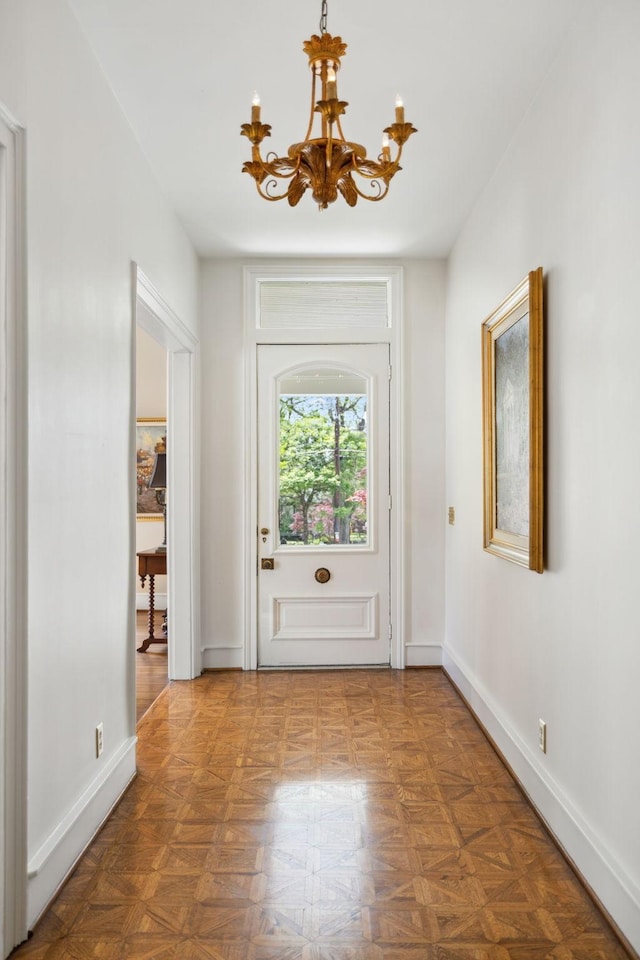 entryway with baseboards and a notable chandelier