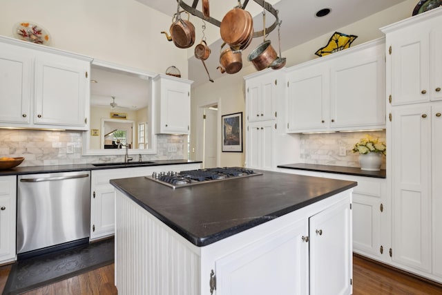 kitchen with white cabinetry, dark countertops, appliances with stainless steel finishes, and a sink