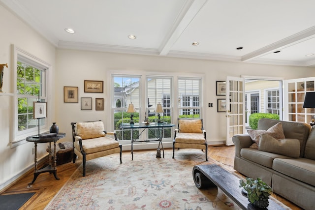 living area with crown molding, baseboards, wood finished floors, and beamed ceiling