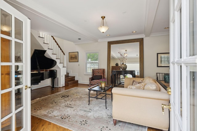 living room with french doors, ornamental molding, wood finished floors, and stairway