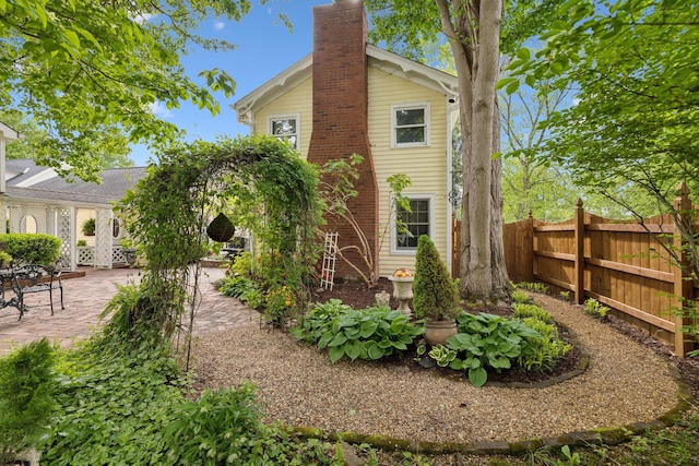 rear view of property with fence, a chimney, and a patio area