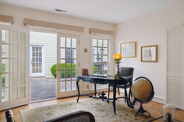 home office featuring visible vents, wood finished floors, and french doors