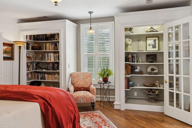 living area with visible vents and wood finished floors