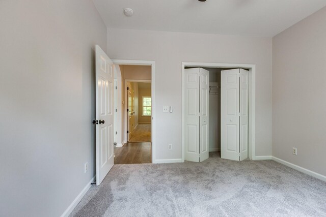 unfurnished bedroom with baseboards, carpet, and a closet