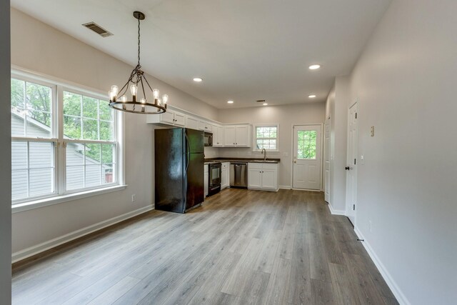 kitchen with a notable chandelier, light wood-style floors, white cabinetry, visible vents, and black appliances