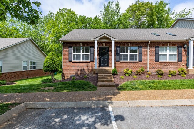 view of front of home with brick siding and a shingled roof