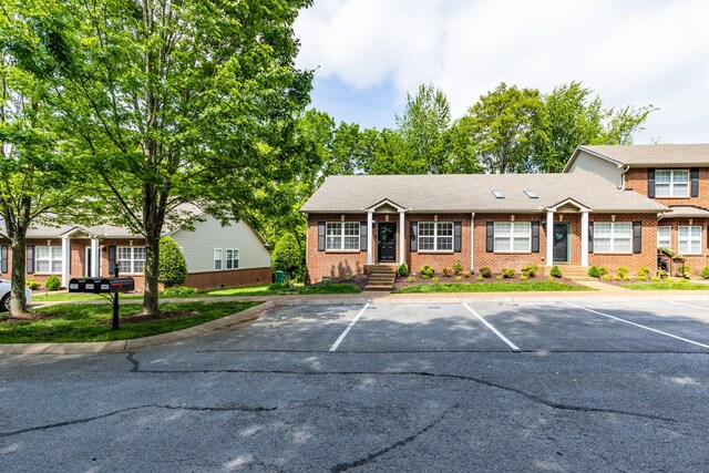 view of front of property with brick siding and uncovered parking