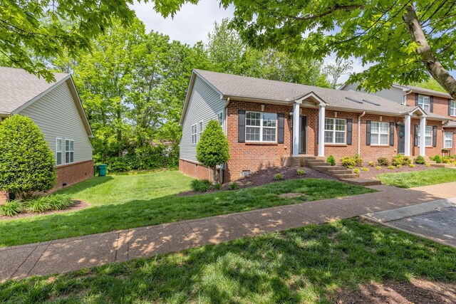 view of front of property with brick siding and a front lawn