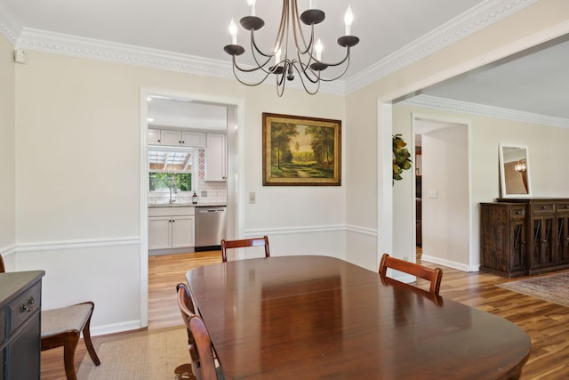 dining area featuring an inviting chandelier, light wood-style flooring, and crown molding