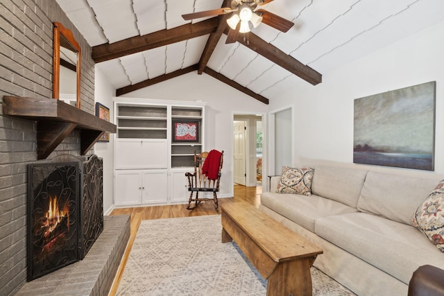 living room featuring a fireplace, ceiling fan, lofted ceiling with beams, and wood finished floors