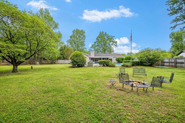 view of yard with a fenced backyard and a fire pit