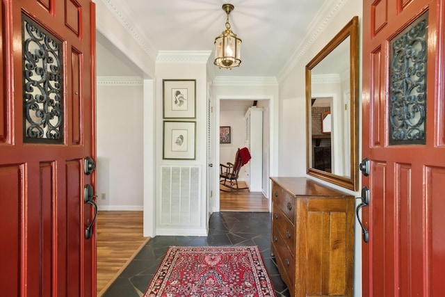 entryway featuring visible vents, dark tile patterned flooring, baseboards, a notable chandelier, and ornamental molding