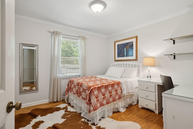 bedroom with baseboards, ornamental molding, and light wood-style flooring