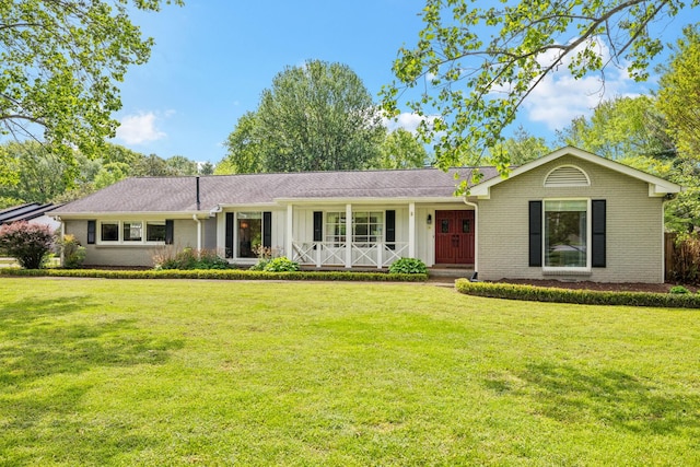 single story home featuring covered porch, brick siding, and a front lawn