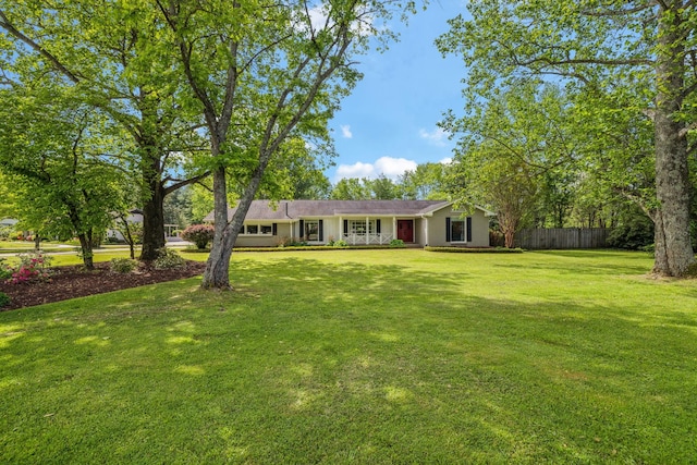 ranch-style house with fence and a front lawn