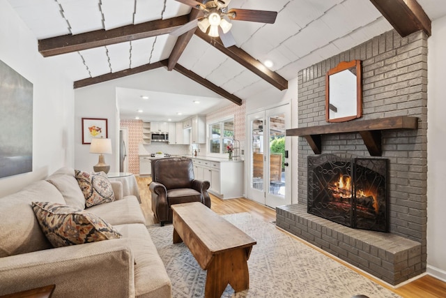 living room with ceiling fan, a fireplace, lofted ceiling with beams, light wood-style floors, and recessed lighting