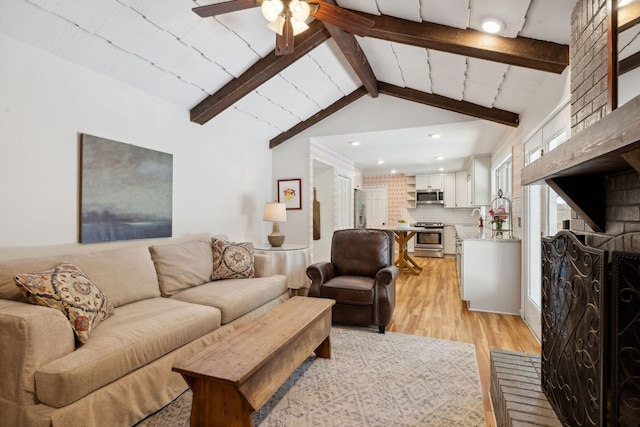 living area with recessed lighting, lofted ceiling with beams, light wood-style flooring, and ceiling fan