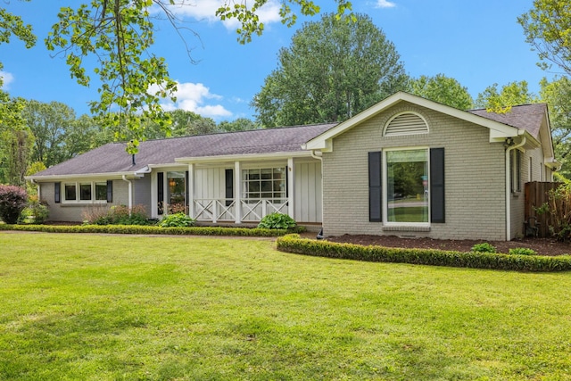 ranch-style house with brick siding, a front lawn, and board and batten siding