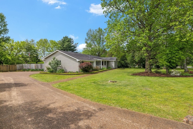 view of yard featuring fence and driveway