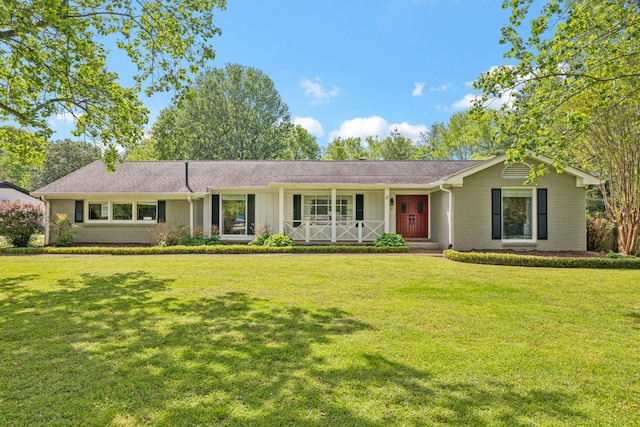ranch-style home featuring brick siding, a front lawn, and covered porch
