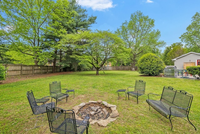 view of yard with a fire pit and a fenced backyard