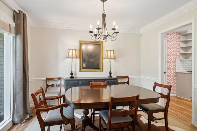 dining room with light wood-style floors, baseboards, an inviting chandelier, and ornamental molding