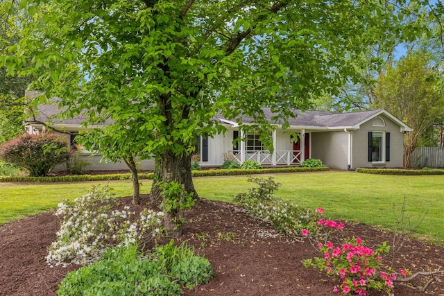 view of front of home with fence, covered porch, a front lawn, and brick siding