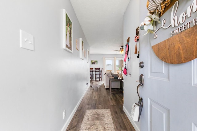hall with dark wood-style flooring and baseboards