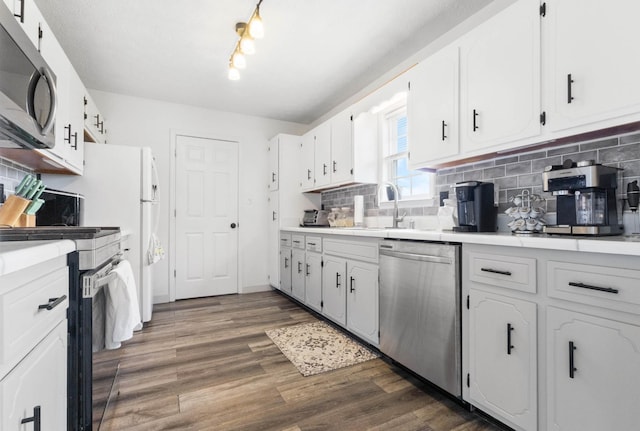 kitchen featuring decorative backsplash, appliances with stainless steel finishes, a sink, light countertops, and white cabinetry