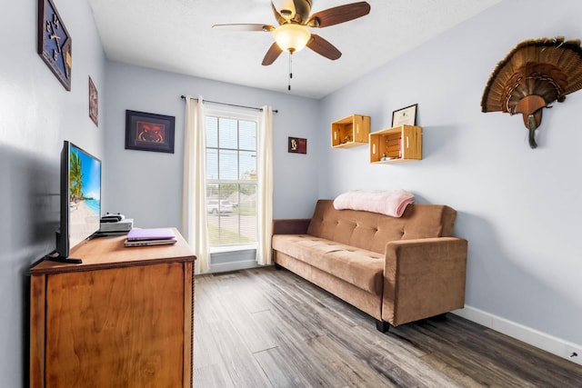 interior space featuring baseboards, ceiling fan, and dark wood finished floors