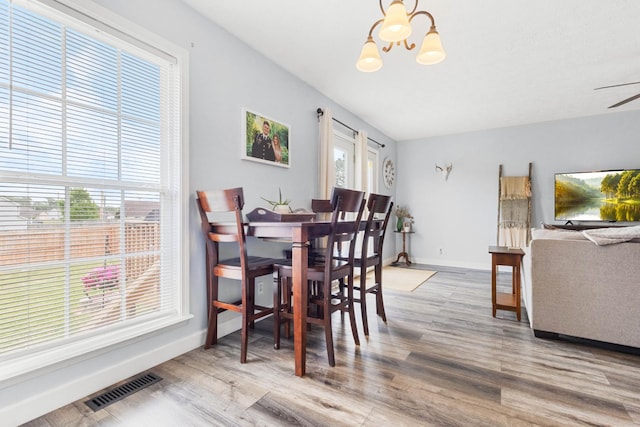 dining room featuring visible vents, baseboards, ceiling fan with notable chandelier, and wood finished floors
