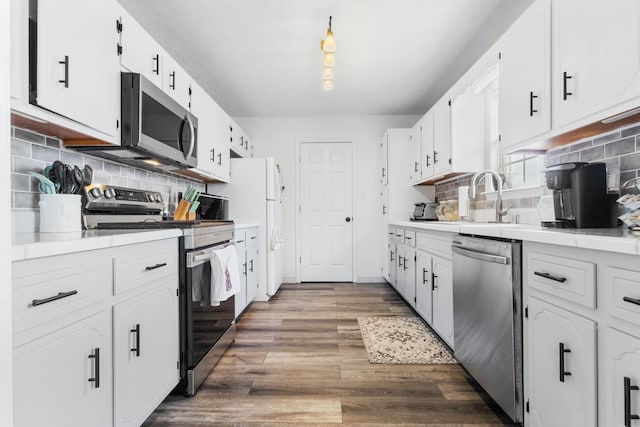 kitchen with a sink, tasteful backsplash, stainless steel appliances, and wood finished floors