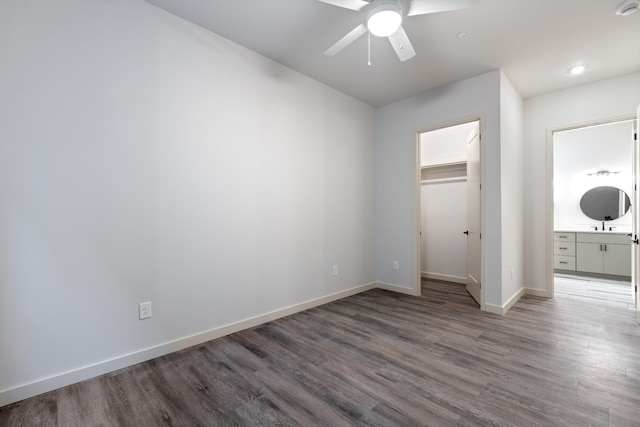 1014 16th Ave S Unit 202, Nashville, TN 37212 - unfurnished bedroom featuring a walk in closet, baseboards, wood finished floors, ensuite bathroom, and a closet
