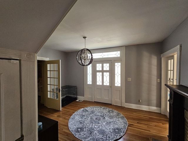entryway featuring baseboards, a notable chandelier, and wood finished floors