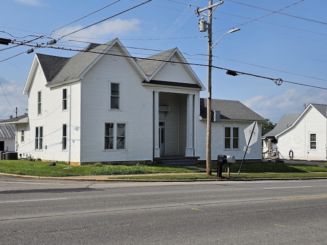 view of front of home featuring central air condition unit and roof with shingles