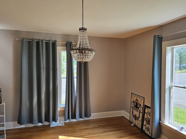 room details with baseboards, an inviting chandelier, wood finished floors, and visible vents